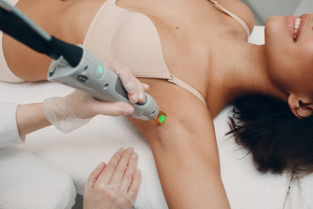 Woman receiving underarm laser hair removal treatment.